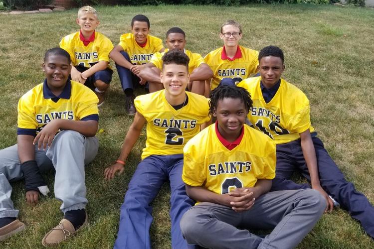 7th & 8th grade boys are gathered for a spirit rally before their big football game. St. Nicholas School players are members of the Youngstown Catholic Saints Football team. 