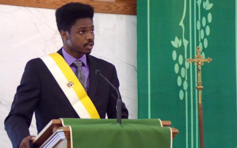 Southern Illinois University student Jamal Kinchen welcomes new members to the Knights of Columbus College Council #7682.